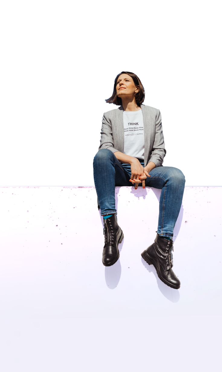 Isabell sitzt auf einer Mauer